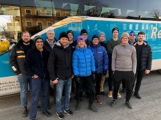 En grupp resenärer som står vid en buss